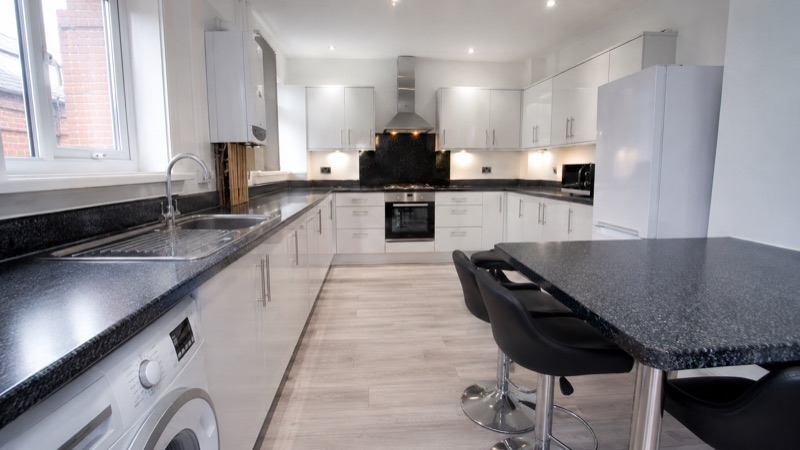 Clean shared kitchen with worktops, appliances and communal seating